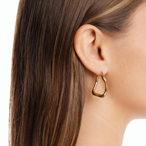 Dusk women's hoop earring by Five Jwlry, a distinctive creation from Alicia Moffet's collaboration. It features an organic, one-of-a-kind design, making it a standout piece. Available in 14k gold or silver, crafted from water-resistant 316L stainless steel. Hypoallergenic with a 2-year warranty.